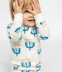 Child posing in a comfy Goodnight Hannukah print on Kids Unisex Pajamas Set made of 100% organic cotton