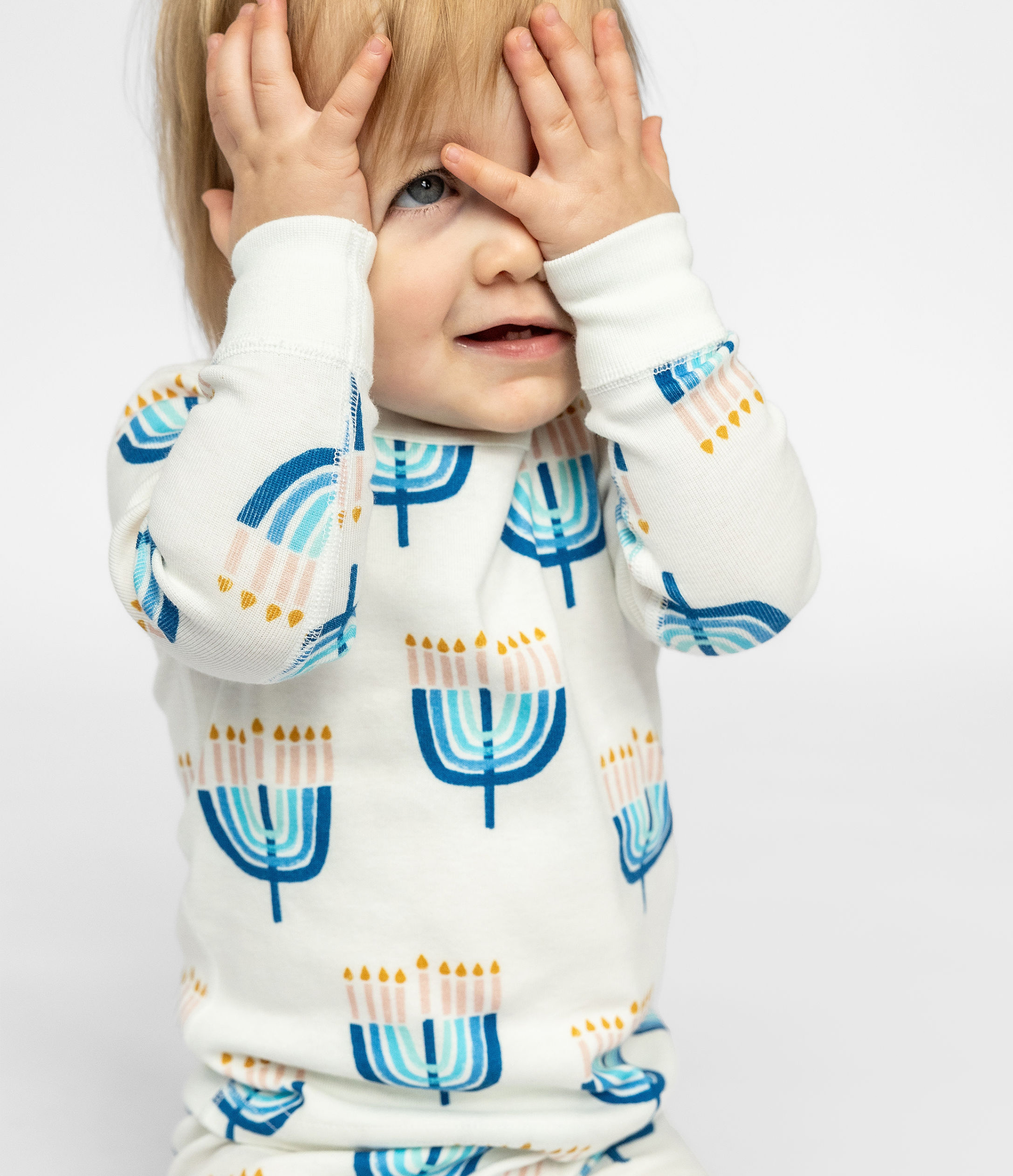 Child posing in a comfy Goodnight Hannukah print on Kids Unisex Pajamas Set made of 100% organic cotton