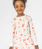 Cute 4 Year Old Girl with White with Fun Red North Pole-themed Graphics, Long Sleeves Top from the Long-john Pajama Set. Comfortable and Cozy Sleepwear for Kids. 100% Organic Cotton.