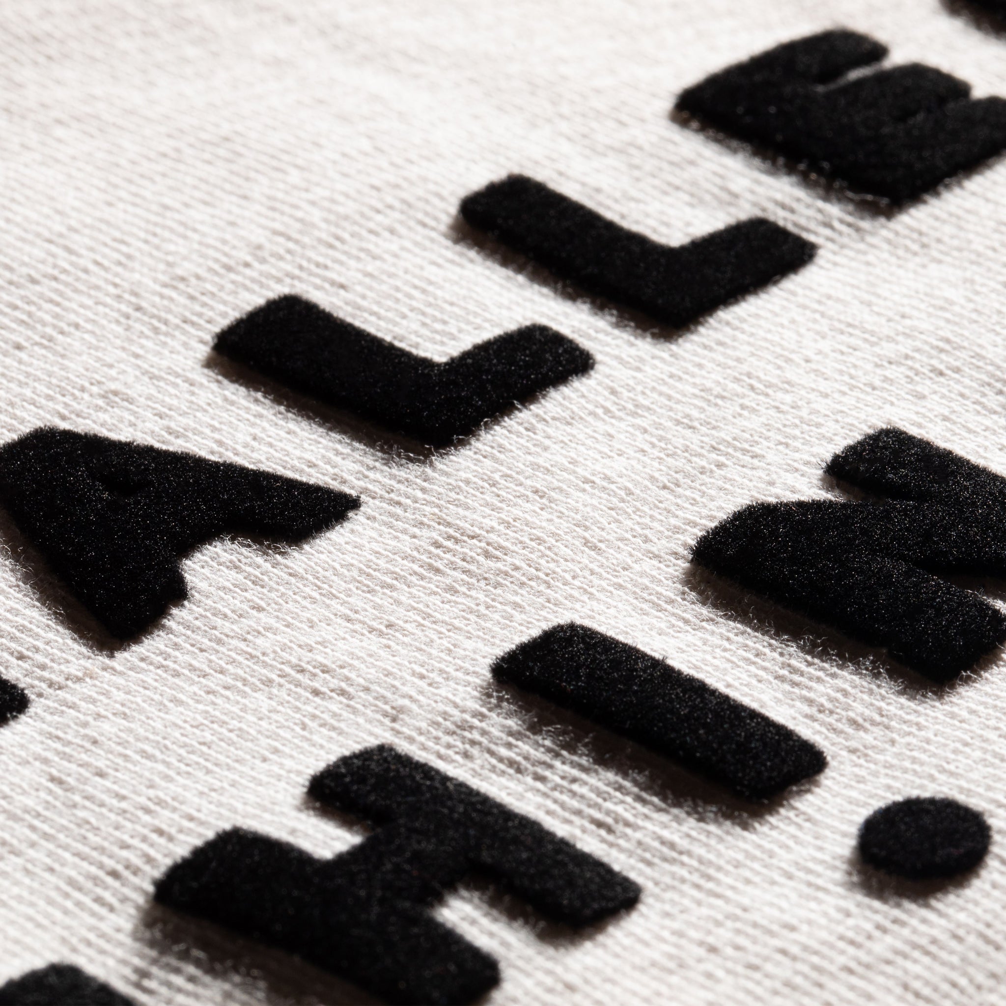 Close Up View of Logo in Charming Velvet Lettering. 100% Organic Cotton. Fashionable and Stylish Wear.
