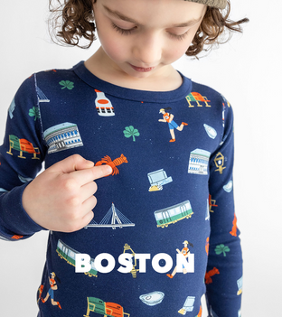 Boy wearing Boston printed pajama pointing to his chest