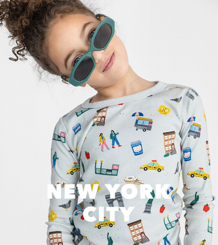 Girl tilting her head while wearing sun glasses and New York City printed pajama